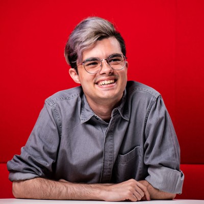 Francisco, a student from Spain, sitting in a red booth in the Fusion Building on our Talbot Campus