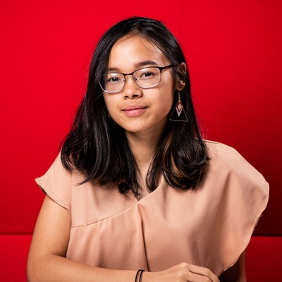 Keisha, a student from Indonesia, sitting in a red booth in the Fusion Building on our Talbot Campus