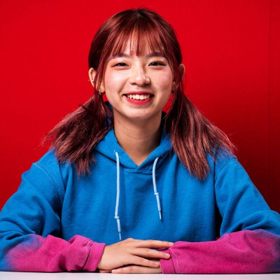 Doris, a student from China, sitting in a red booth in the Fusion Building on our Talbot Campus