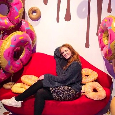 Emma Brooks Emma Brooks, a BU student, on placement at an event sat at a set surrounded by large novelty doughnut decorations