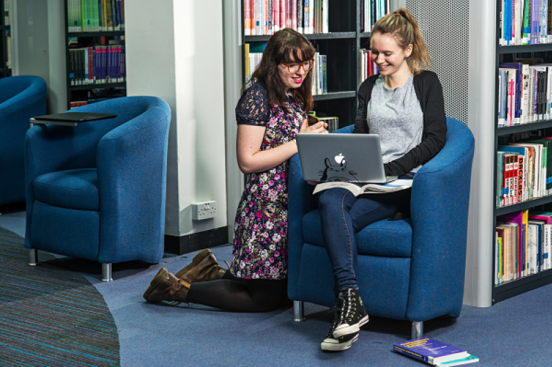 Two students looking at a laptop