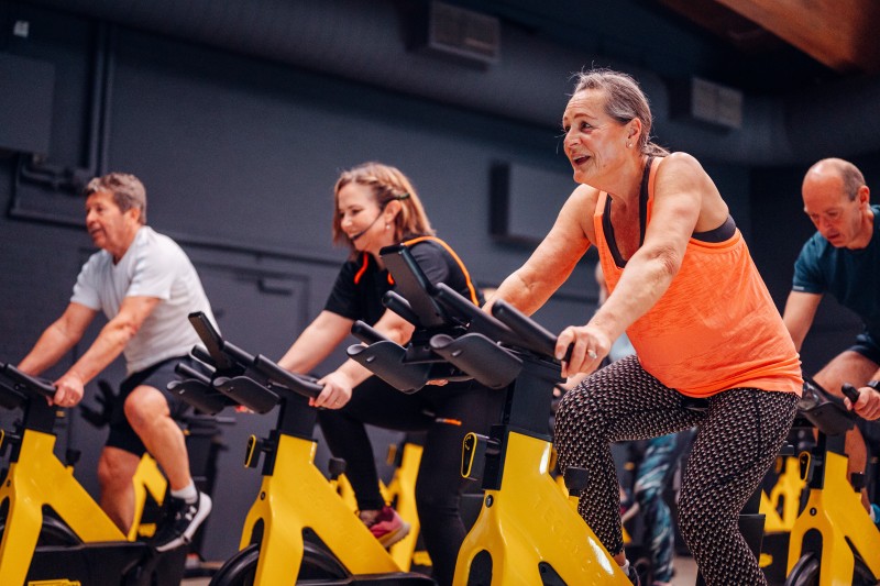 A group of participants on static bikes during a CHAIN class