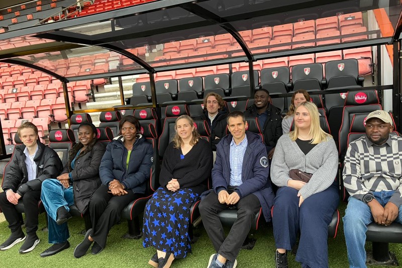 BU students in the dugout pitchside at the Vitality Stadium