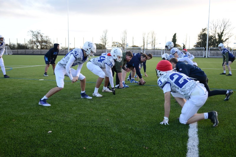 The BU Bobcats – Bournemouth University's American Football Team – playing on the Chapel Gate community pitch A group of men in american football kit, crouching down about to start play