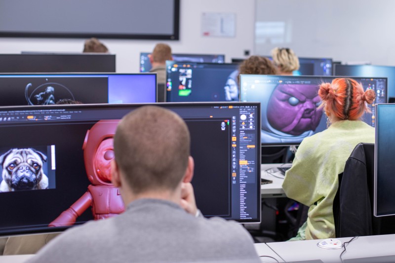 Attendees in a computer lab, their screens show computer animated characters.