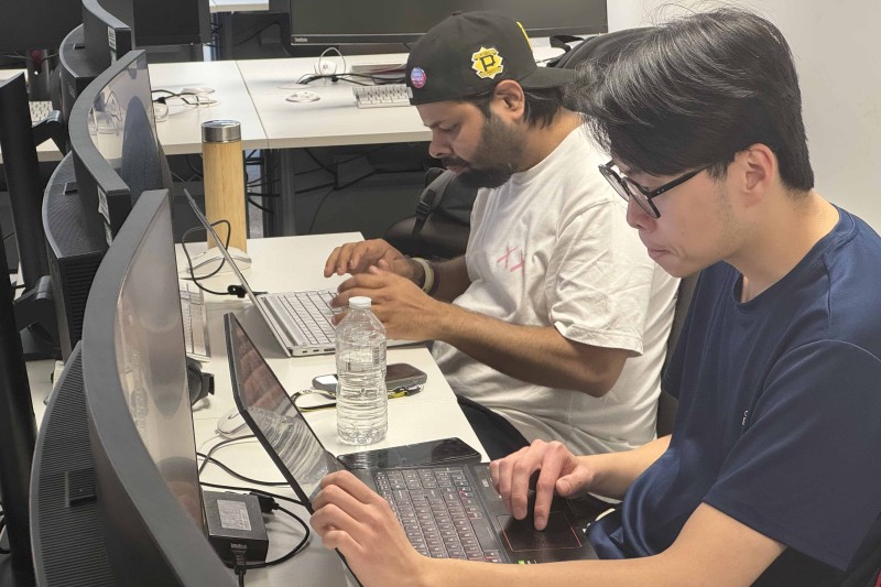 Two men working on stories at their computers