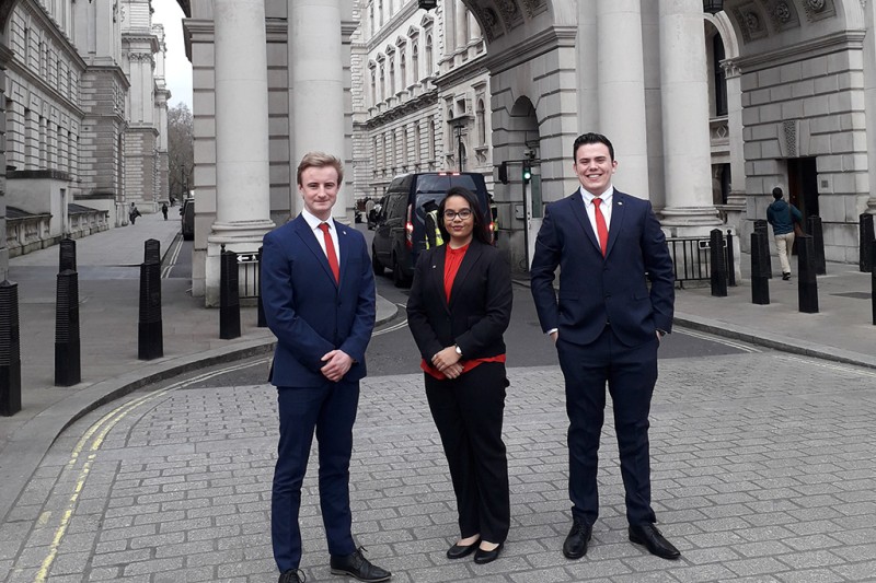 The three BU students standing in the street leading up to the FCDO