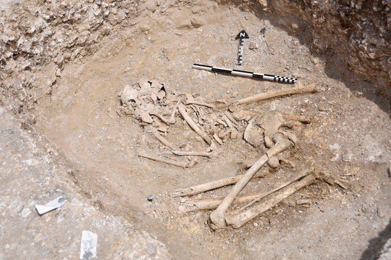 A human skeleton crouched in a foetal position.