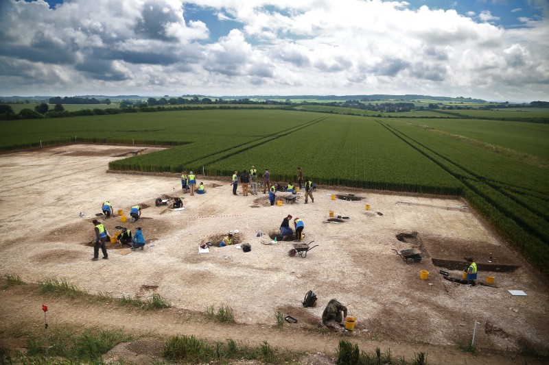 A landscape showing the excavation site with rural countryside fields in the background.