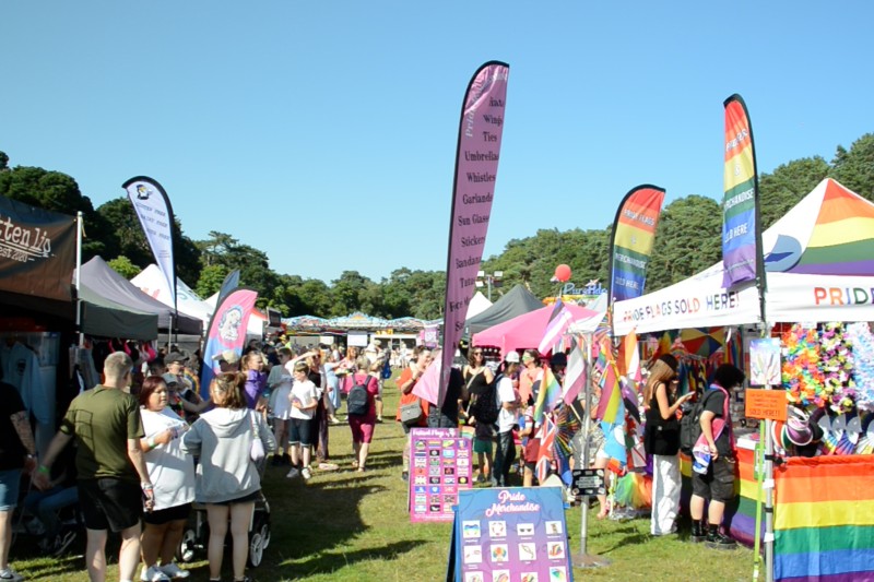 rows of stalls with Pride rainbow flags all around them