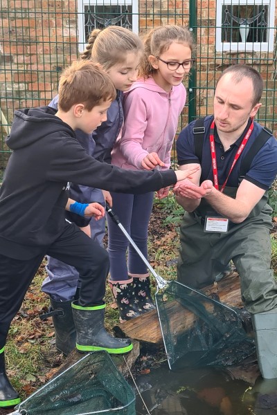 Ben Parker, BU PhD student showing pupils at St. Luke's a newt