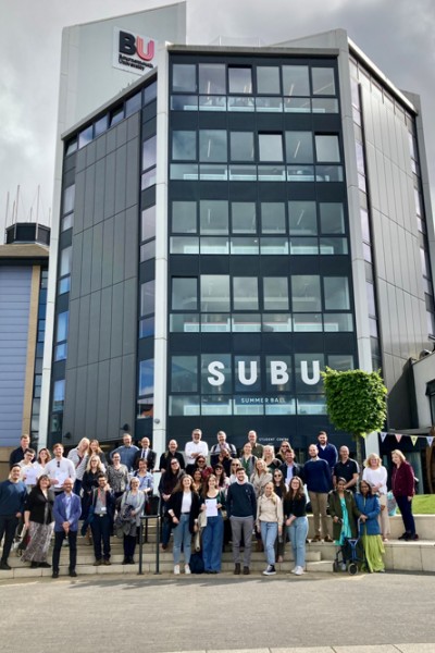 A photograph of C&J students and staff gathering outside the SUBU building