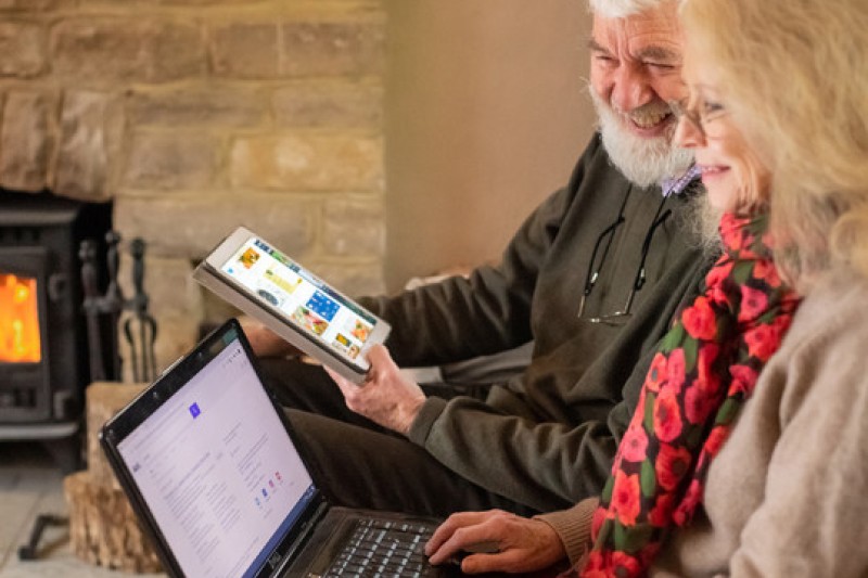 An older couple using their smart devices An older couple using their smart devices