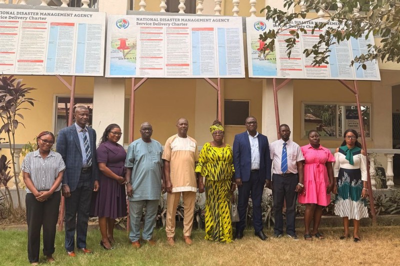 Staff members at the NDMA standing outside below the billboards in Freetown Staff members at the NDMA standing outside below the billboards in Freetown