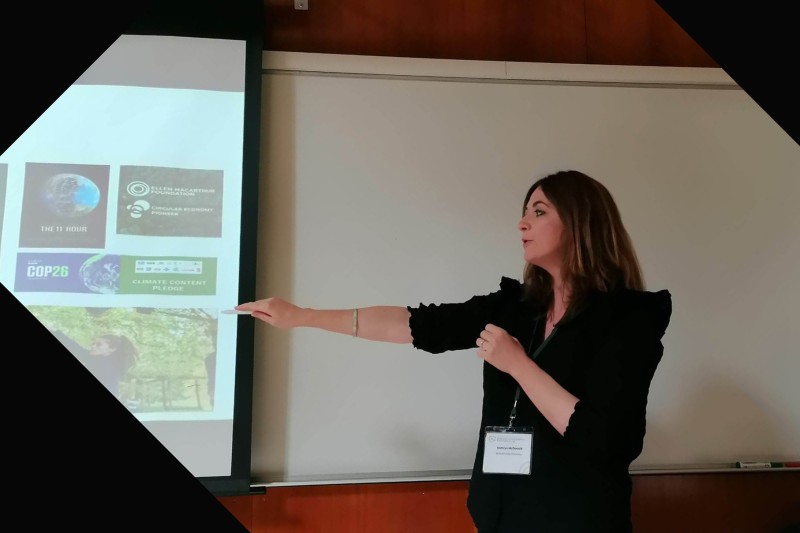 Dr Kathryn McDonald Dr Kathryn McDonald presenting - pointing to a screen with environmental images on