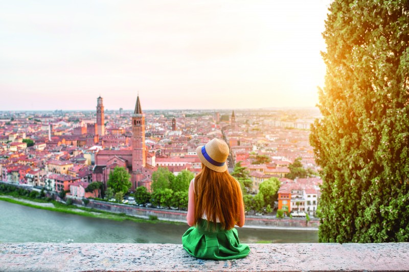 Female in a green dress over-looking a European city 