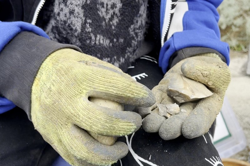A close up piece of flint being shaped into a tool A piece of flint being shaped into a tool