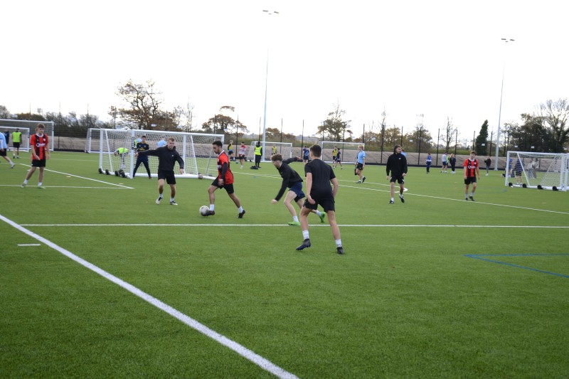 A group of men playing football on the Chapel Gate multi-sports community pitch A group of men playing football