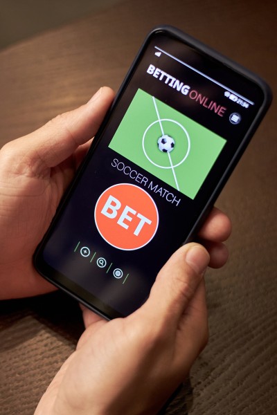 Hands holding a mobile phone with gambling app