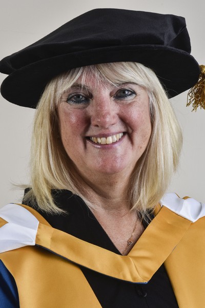 A lady in her ceremonial robes looking at the camera smiling