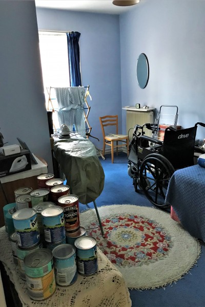 Bedroom with washing rack and tins of food