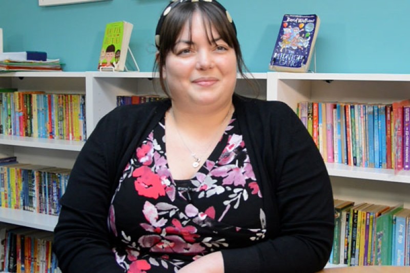 Head Teacher at St. Luke's school siting in front of a bookcase