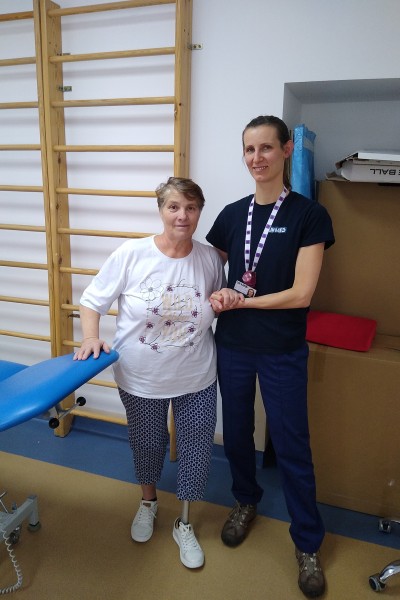 Lauren Eve in her physio uniform with patient Marta, both looking at the camera smiling