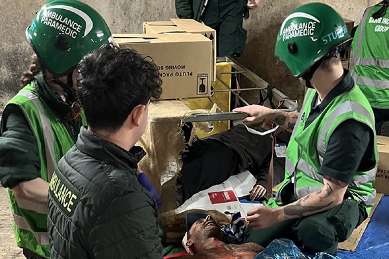 Paramedic students gather round an injured volunteer on the ground