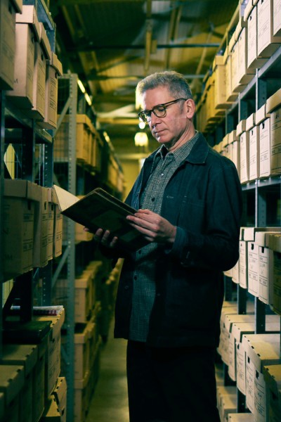 A picture of Dr Innes McCartney viewing the archive documents at the HEC