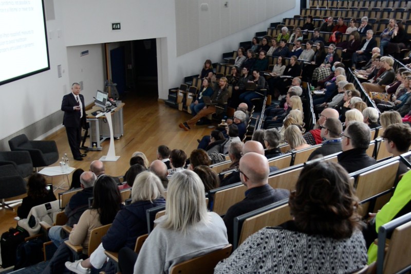 Photo from the back of the lecture theatre showing the audience looking at JVT as he talks