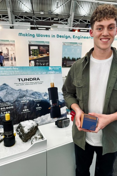 Jake holding his award, next to his tundra product on display. 