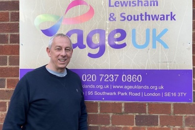 Jeff Porter stood in front of an Age UK sign