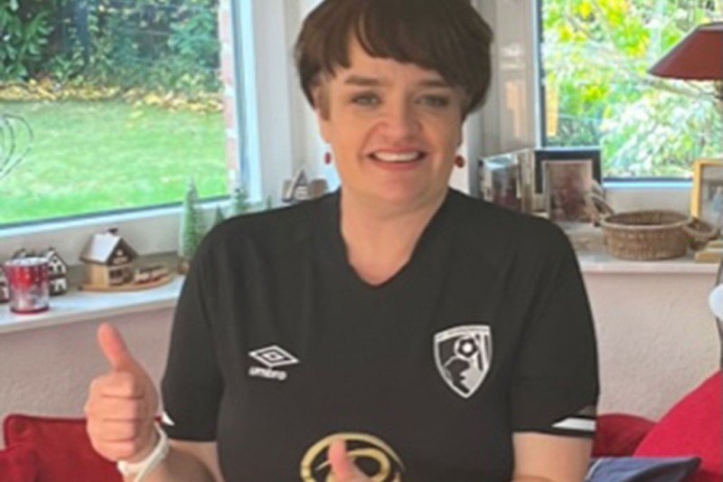 A lady wearing an AFCB shirt with her thumbs up