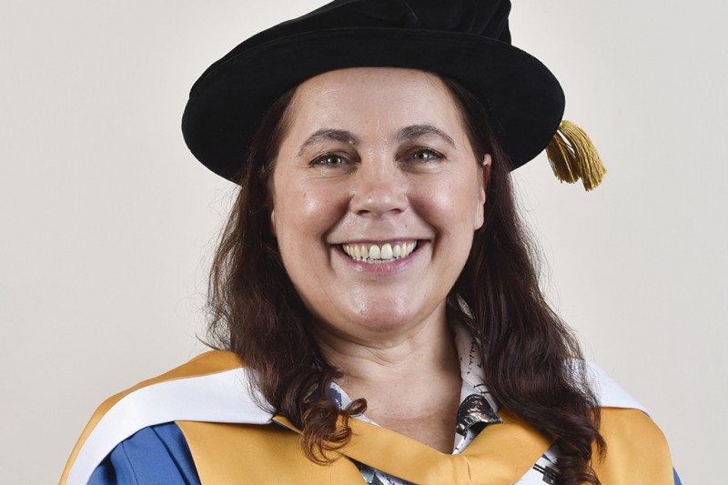 A lady in her ceremonial robes looking at the camera smiling