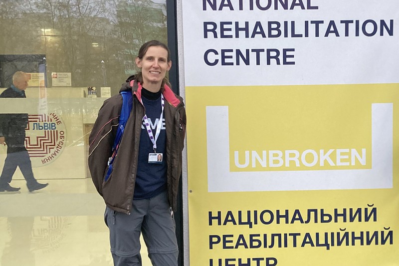 Lauren Eve standing by the hospital sign which reads "National Rehabilitation Centre"