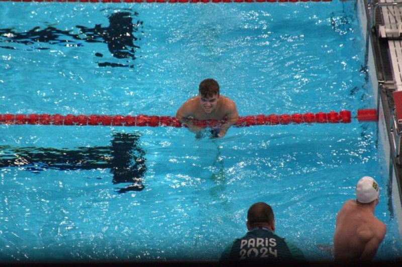 Leo in the pool after the race, leaning over a lane rope
