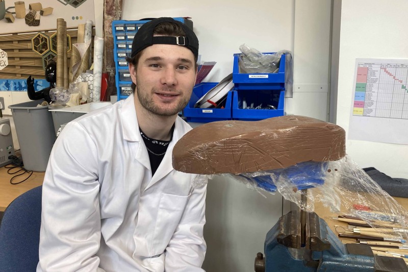 Lewis in the workshop with a mould of a show in front of him