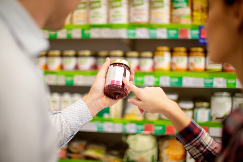 A photo of two people reading the label of a jar.