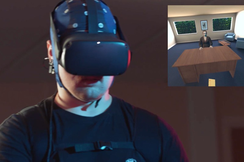 A man in a VR headset with the virtual reality scene of a man sat at a desk