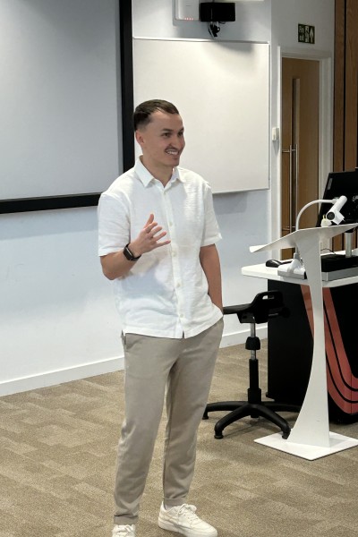 Mark standing at the front of a lecture theatre speaking