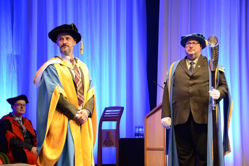 Max McMurdo Max Murdo standing on the stage in his ceremonial graduation robes