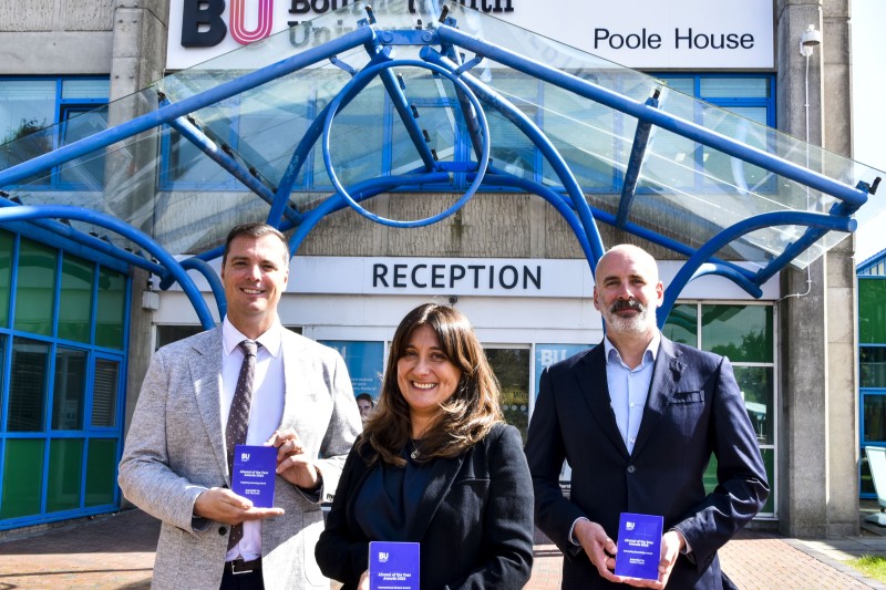 Award winners Three award winners holding their awards in front of Poole House, Bournemouth University