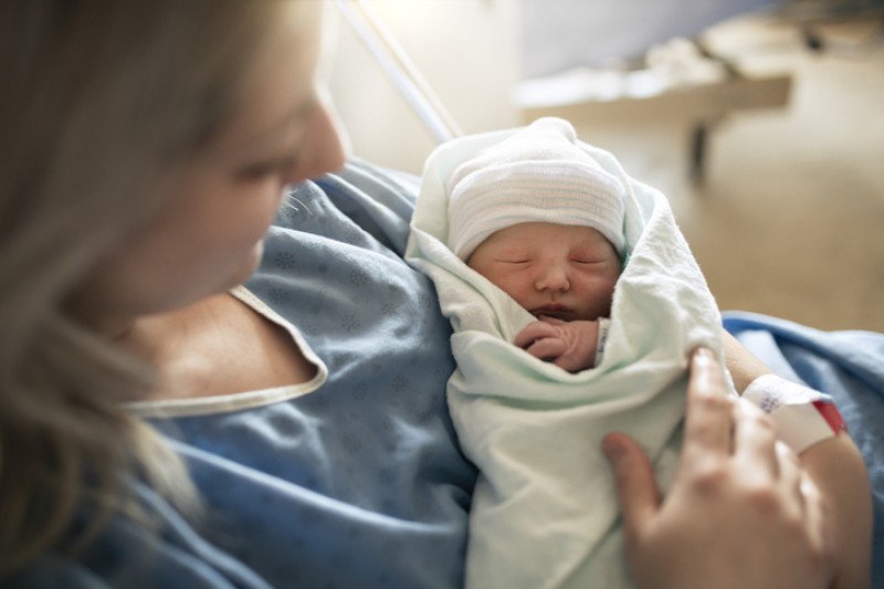 A mother holding her newborn baby in hospital