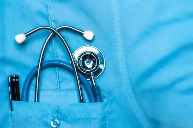 A scrubs shirt with medical implements in the pocket