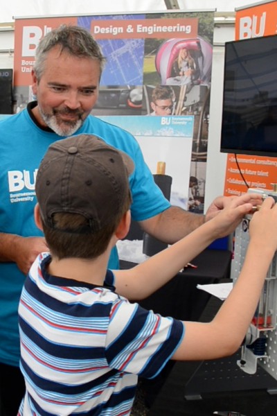 Paul Domoney demonstrating the tensile test machine to a young visitor