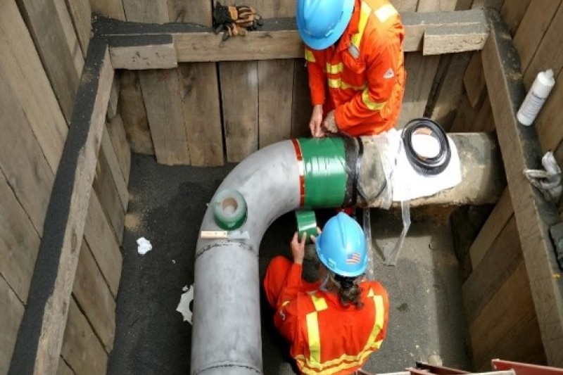 Two people repairing a pipeline