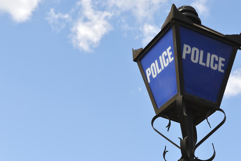 An old fashioned blue lamp with POLICE written on it