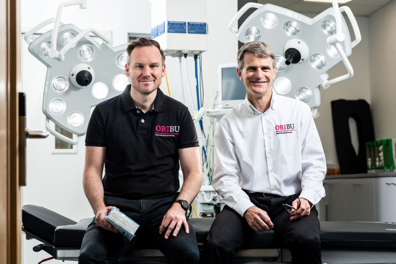 Professor Tom Wainwright and Professor Robert Middleton from the Orthopaedic Research Institute Professor Tom Wainwright and Professor Robert Middleton sat on an operating table