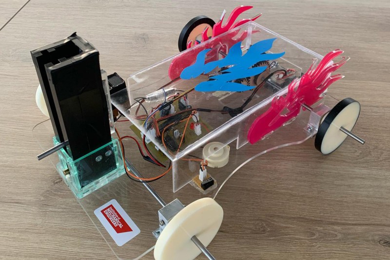 A mechanical four wheeled vehicle with a small engine, wires and computer components attached.