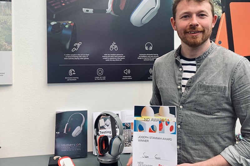 Sam Gaze holds his award next to a prototype of his immersion gaming headset